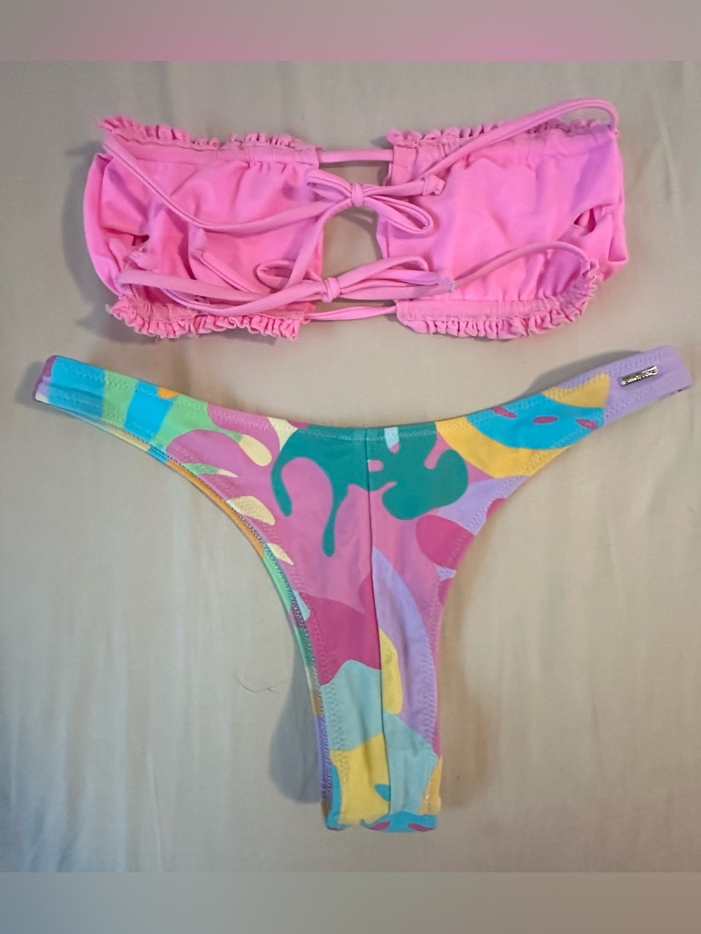 Women’s pink one piece and 2 strapless bikinis, one all pink one w floral bottom